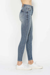Woman wearing Judy Blue high-rise tummy control contrast wash skinny jeans with a flattering skinny-leg fit and light medium wash denim.