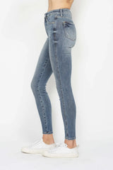 Woman wearing Judy Blue high-rise tummy control contrast wash skinny jeans with a flattering skinny-leg fit and light medium wash denim.