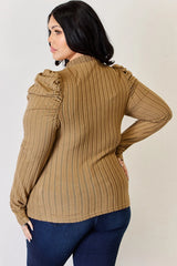 Woman wearing a khaki Basic Bae ribbed mock neck long sleeve top with ruched puff shoulders, paired with dark blue jeans.