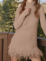 Woman wearing a khaki fringe turtleneck long sleeve sweater dress with brown knee-high boots, a cozy fall outfit from Chic Mystik Boutique.