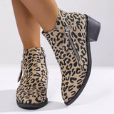 Woman wearing khaki leopard-print ankle boots with block heels and side zipper details.
