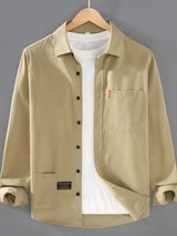 Men’s khaki plus size button-up long sleeve shirt with multiple pockets, shown layered over a white T-shirt.