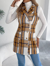 Women’s khaki plaid double-breasted long vest coat with pockets styled over a white turtleneck and jeans.
