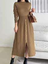 Woman wearing a khaki mock neck long sleeve knit midi dress with pleated skirt, front buttons and slit.