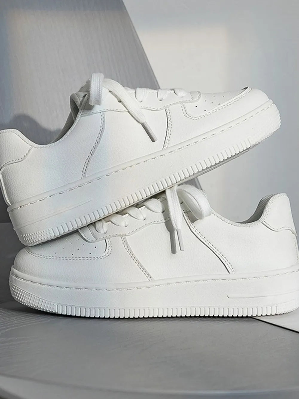 Pair of white sneakers on a light gray background