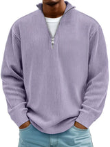 Man wearing a lavender ribbed corduroy quarter zip pullover sweatshirt layered over a white shirt.
