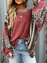 Women's cerise ribbed long sleeve top with leopard and Southwestern-inspired color block prints styled with blue jeans.