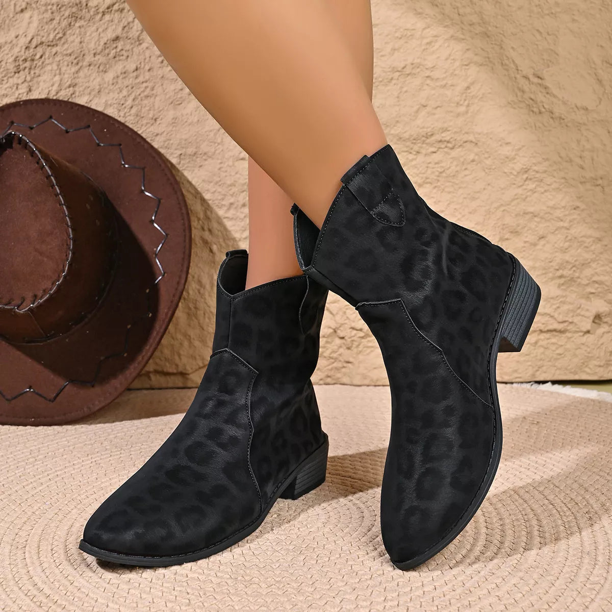 Women's black leopard print western ankle boots with subtle animal print, pointed toes and low block heels.