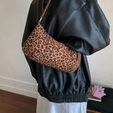 Leopard suede vintage-style shoulder bag with a minimalist silhouette paired with a neutral outfit.