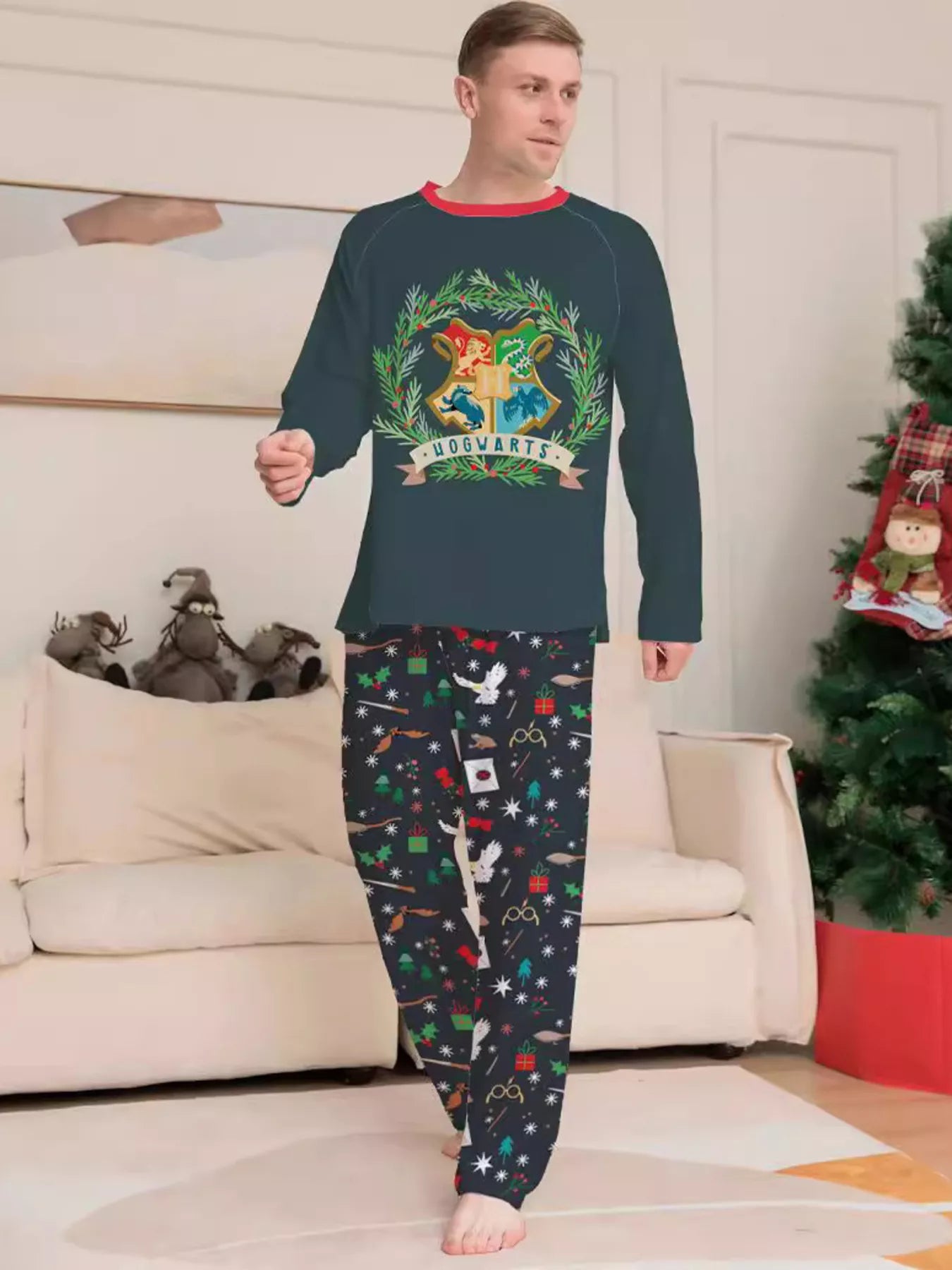 Family wearing matching dark green Hogwarts graphic Christmas pajama tops with coordinating navy holiday print pajama pants.