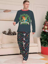 Family wearing matching dark green Hogwarts graphic Christmas pajama tops with coordinating navy holiday print pajama pants.