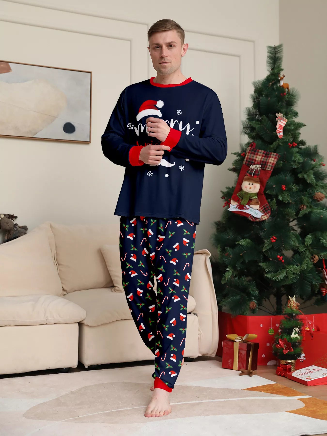 Man wearing navy blue Merry Christmas pajama sets with red trim and holiday-print pants.