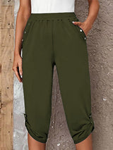 Model wearing matcha green roll-tab capri pants with side pockets and white sneakers for a casual outdoor look.