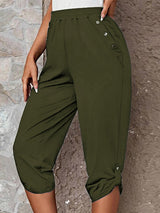 Model wearing matcha green roll-tab capri pants with side pockets and white sneakers for a casual outdoor look.