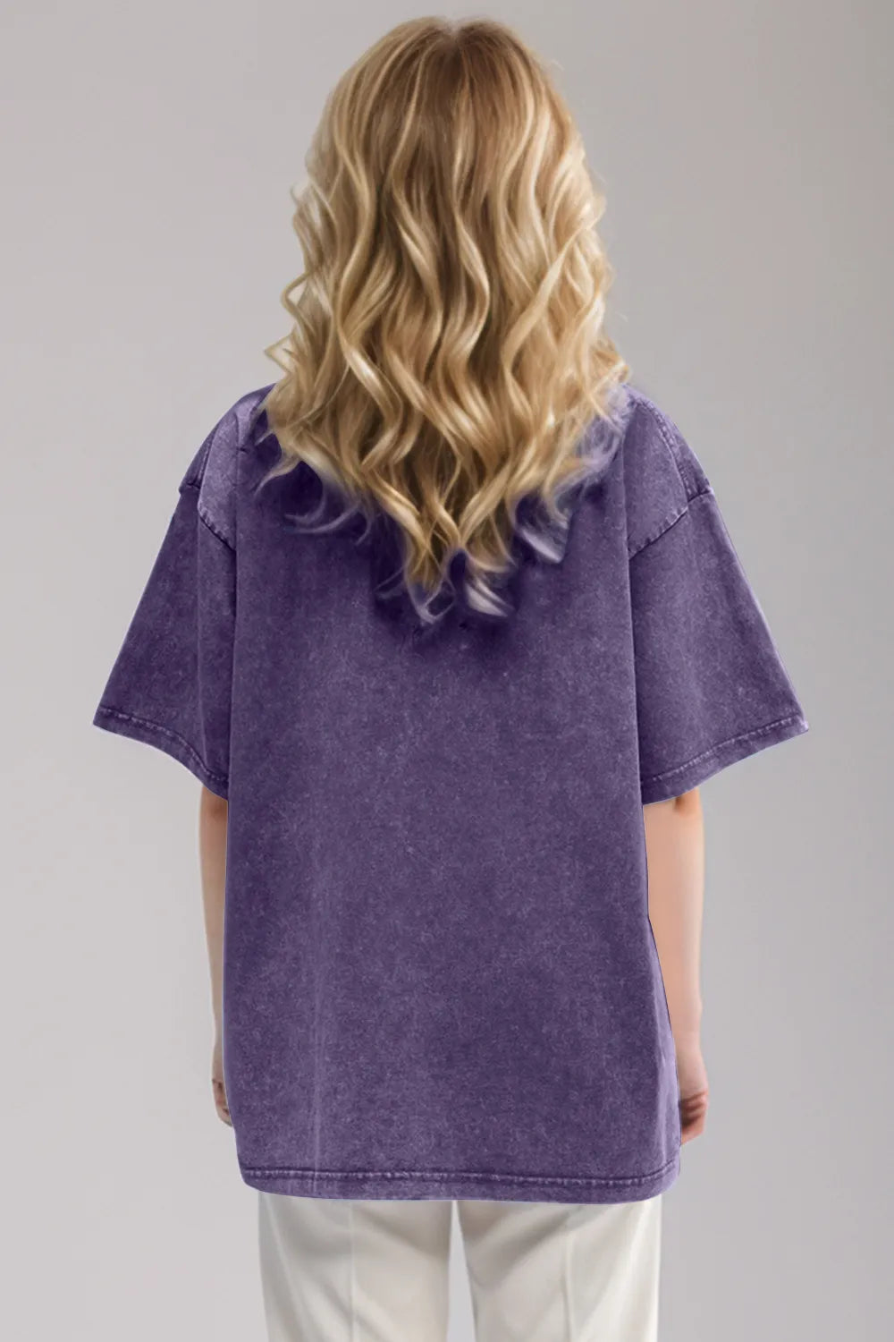 Woman wearing an oversized mauve Basic Bae round-neck half-sleeve T-shirt styled with dark denim jeans and a long pendant necklace for a relaxed, casual look.