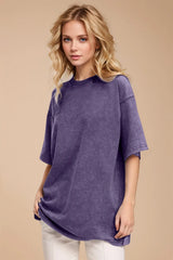 Woman wearing an oversized mauve Basic Bae round-neck half-sleeve T-shirt styled with dark denim jeans and a long pendant necklace for a relaxed, casual look.