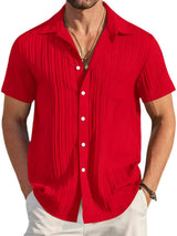 Man wearing a red textured short sleeve button-up shirt with white pants for a polished casual summer look.