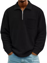 Man wearing a black ribbed corduroy half zip long sleeve casual top with collar and chest pocket.