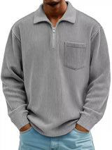 Man wearing a gray ribbed corduroy half zip long sleeve casual top with collar and chest pocket. 