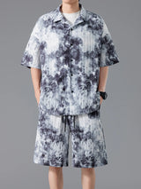 Men's plus size tie-dye two-piece outfit featuring a short sleeve button-up shirt and matching drawstring shorts in a dark navy and sage print.