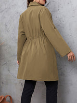 Woman wearing the Honey Plus Size Lapel Collar Drawstring Roll-Tab Sleeve Trench Coat in mocha with black denim and a black top, lightweight plus size fall trench coat from Chic Mystik Boutique.