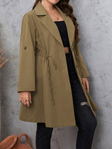 Woman wearing the Honey Plus Size Lapel Collar Drawstring Roll-Tab Sleeve Trench Coat in mocha with black denim and a black top, lightweight plus size fall trench coat from Chic Mystik Boutique.