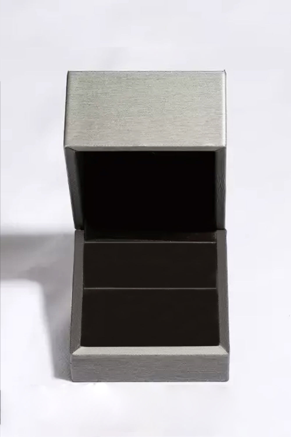 Rhodium-plated 925 sterling silver minimalist ring Box featuring a 0.1 carat round moissanite center stone with delicate sparkling accents on a teal background.