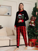 Mom modeling matching Christmas Crew pajama sets with festive black graphic tops and red and black plaid pants.