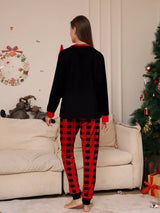 Mom modeling matching Christmas Crew pajama sets with festive black graphic tops and red and black plaid pants.