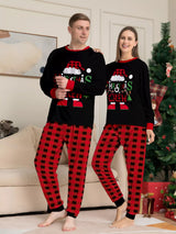 Mom and Dad modeling matching Christmas Crew pajama sets with festive black graphic tops and red and black plaid pants.