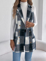 Women’s navy blue plaid double-breasted long vest coat with pockets styled over a white turtleneck and jeans.