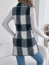 Women’s navy blue plaid double-breasted long vest coat with pockets styled over a white turtleneck and jeans.