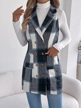 Women’s navy blue plaid double-breasted long vest coat with pockets styled over a white turtleneck and jeans.