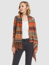 Woman wearing the Angel Wings tassel striped open-front cardigan in ochre, featuring earthy multicolor stripes, a draped asymmetrical front, and long fringe trim.