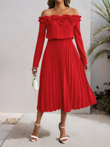 Red off-shoulder dress with ruffled top worn by a person, standing against a neutral background.