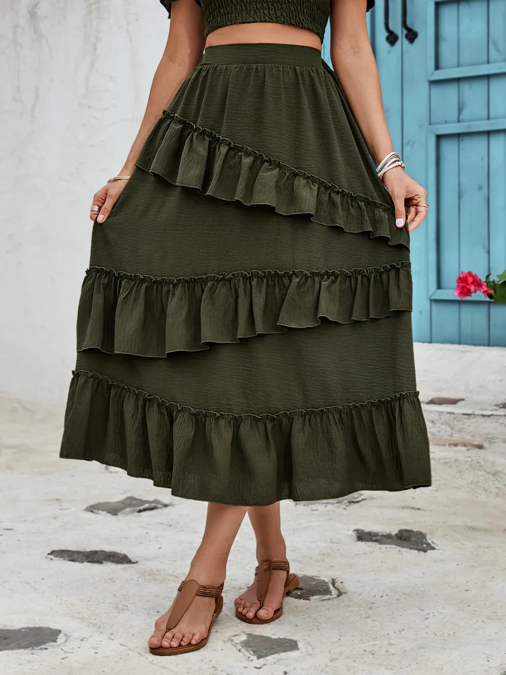 Women's olive-green elastic waist midi skirt with cascading asymmetrical ruffles and ruffled hem.