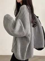 Women's gray open front oversized ribbed knit cardigan layered over a white tank top with black pants, cozy fall sweater for casual everyday style.