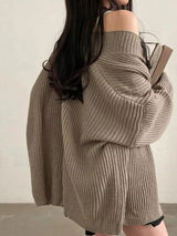 Women's khaki open front oversized ribbed knit cardigan layered over a white tank top with black pants, cozy fall sweater for casual everyday style.