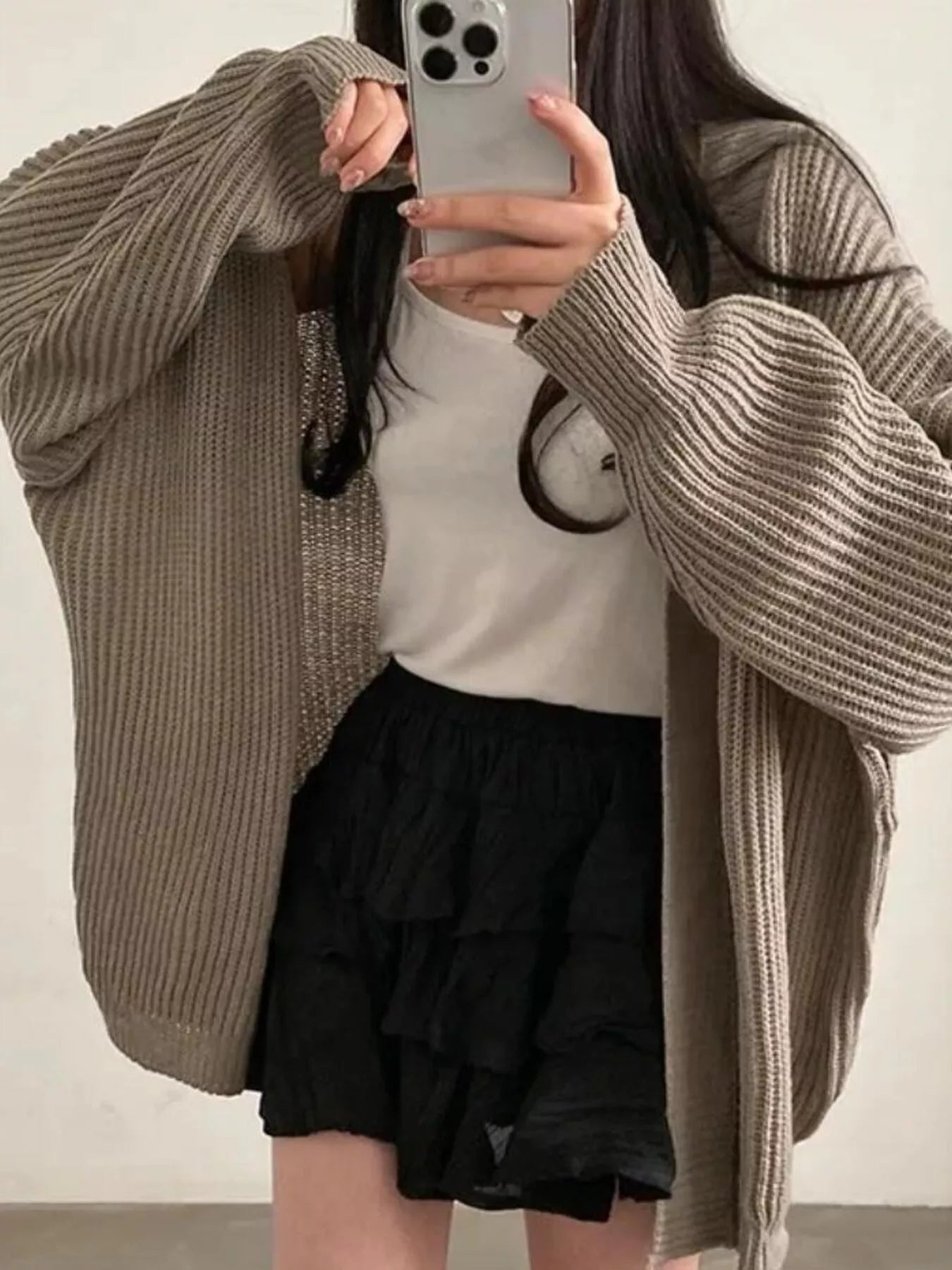 Women's khaki open front oversized ribbed knit cardigan layered over a white tank top with black pants, cozy fall sweater for casual everyday style.