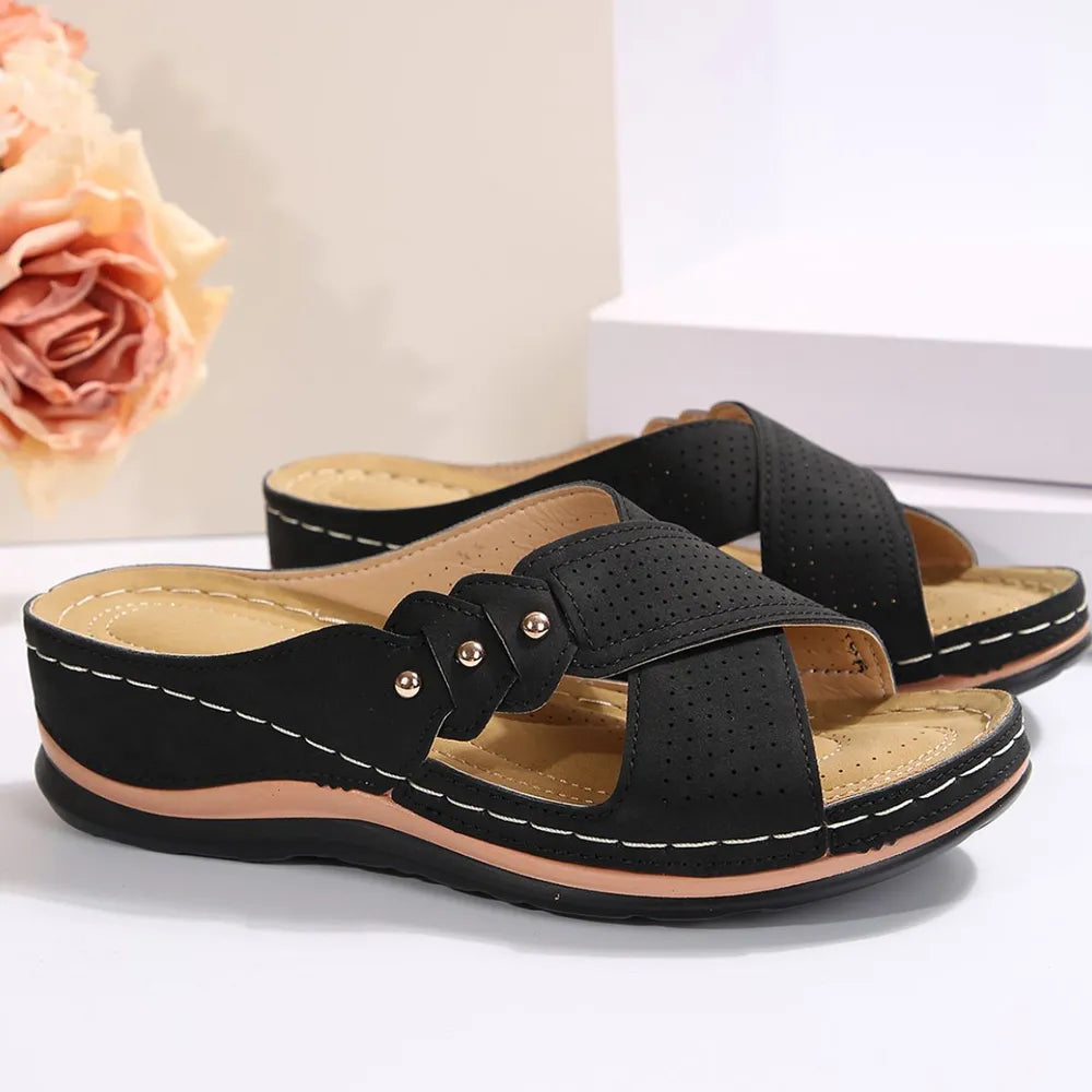 Black sandals with a tan insole on a light background