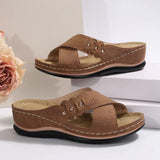 Pair of brown sandals with a flower on a light background