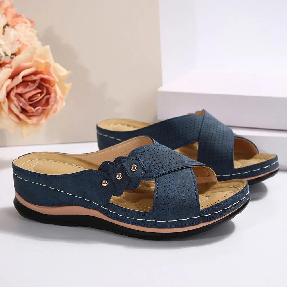 Pair of blue sandals on a white surface with a floral background