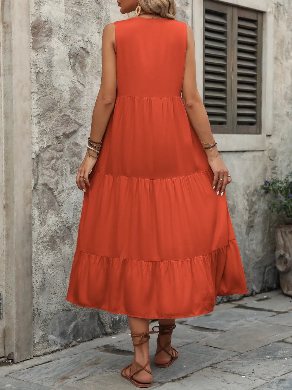 Woman wearing the Ivy Lane decorative button sleeveless dress with a notched neckline and a flattering silhouette.