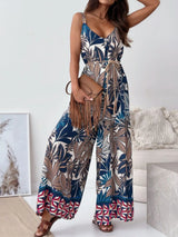 Woman wearing a colorful leaf-patterned jumpsuit with a white background