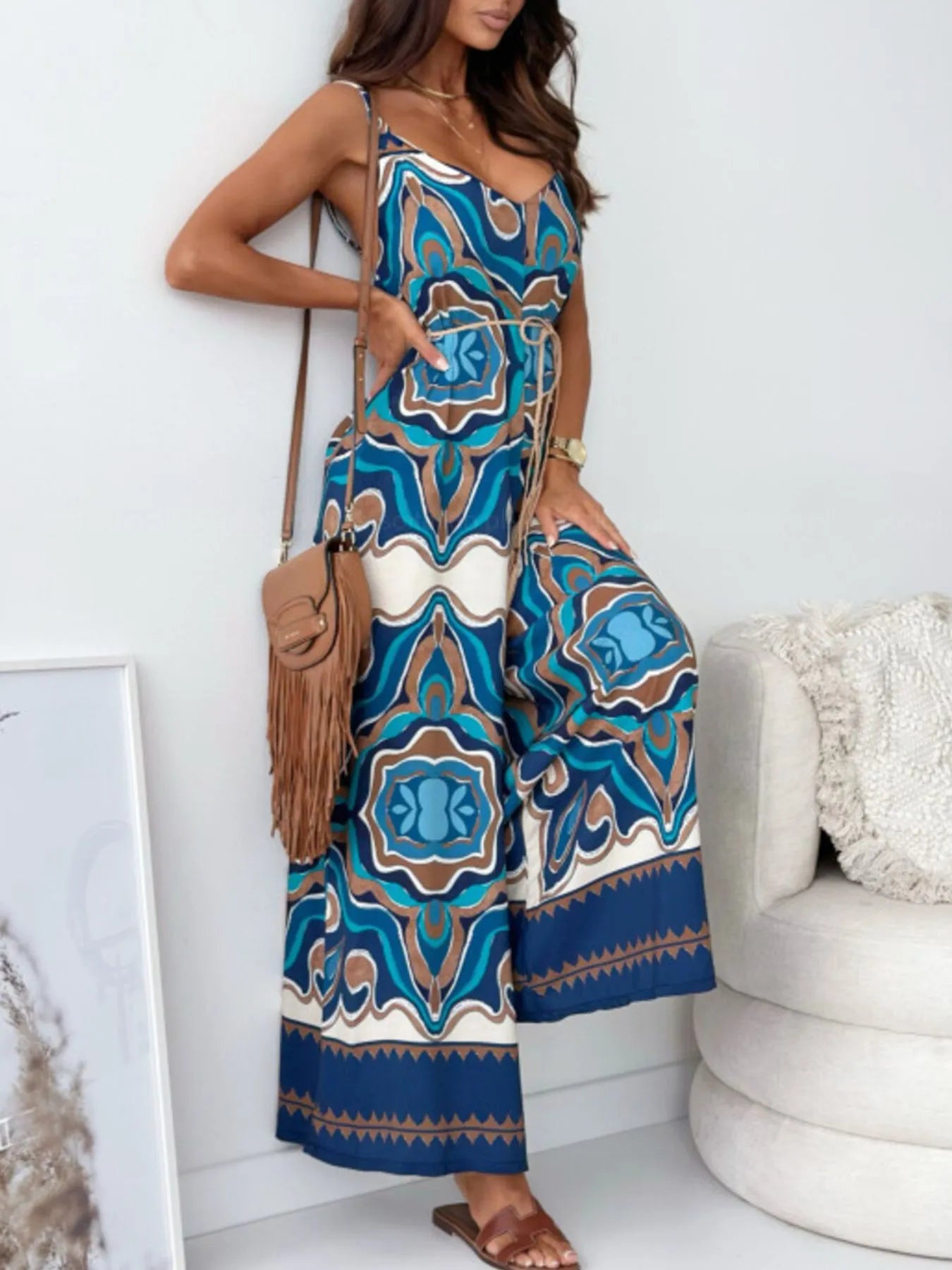 Woman wearing a blue and white patterned jumpsuit in a minimal indoor setting
