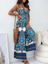 Woman wearing a blue and white patterned jumpsuit in a minimal indoor setting