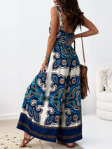 Woman wearing a sleeveless jumpsuit with a blue and white pattern in a minimal indoor setting.