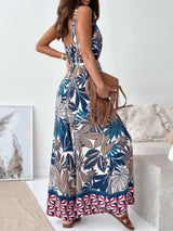 Woman wearing a big leaf patterned jumpsuit with a white background