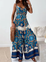 Woman wearing a blue patterned jumpsuit in a minimal indoor setting