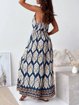 Woman wearing a blue and white patterned jumpsuit in a minimalistic room showcasing the back.